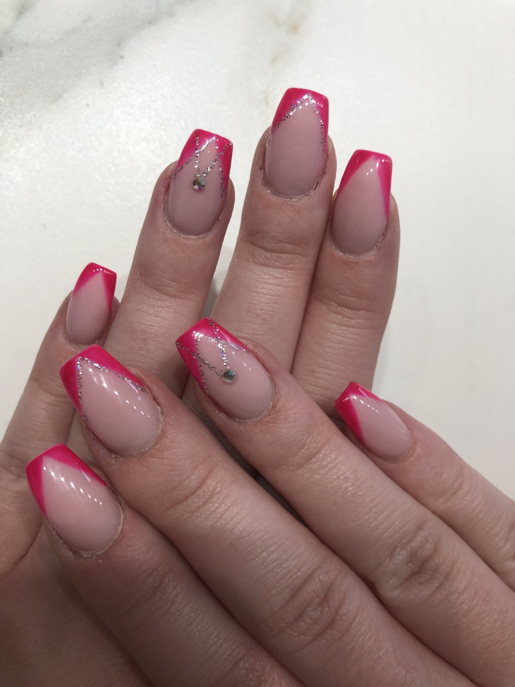 Roze French tips met zilveren glitterlijnen en steentjes