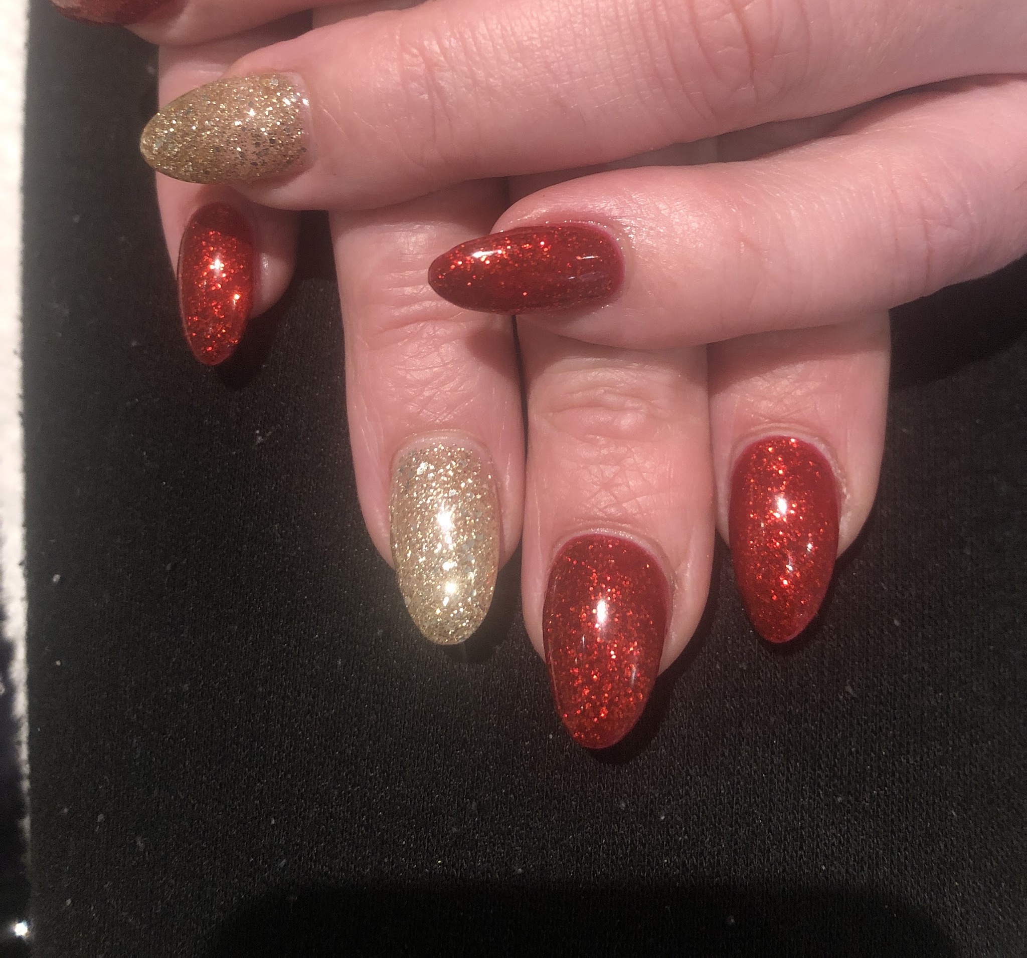 Rode en gouden glitternagels in amandelvorm